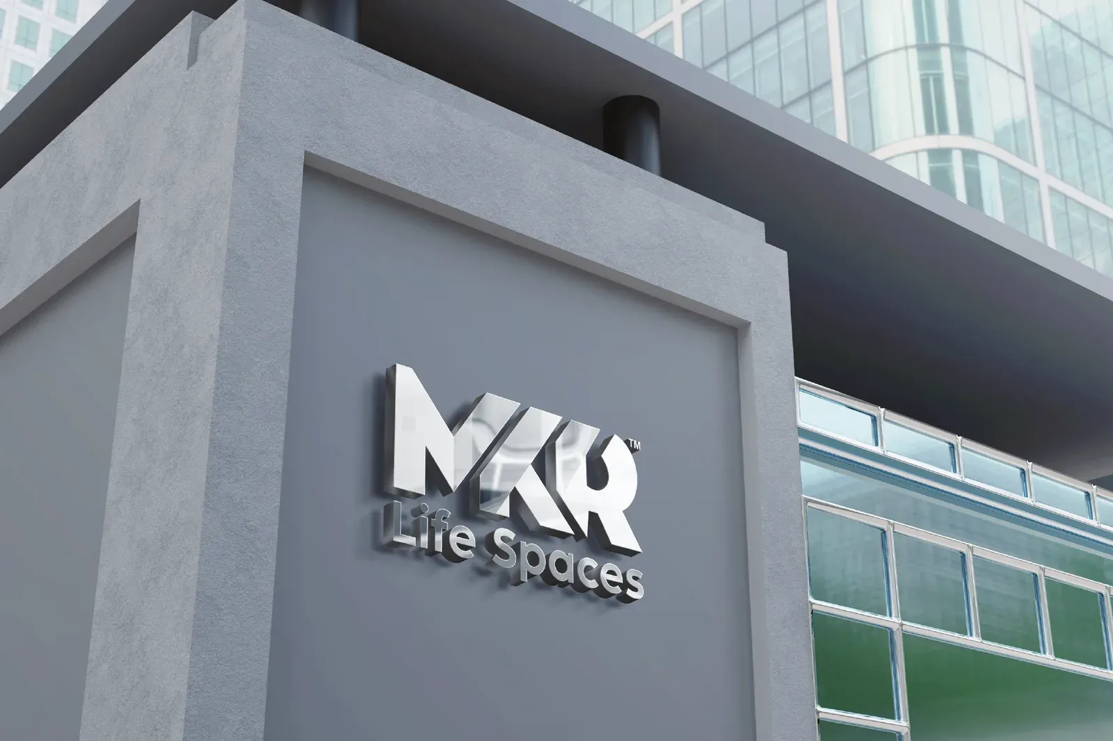 MKR Life Spaces logo in brushed silver on the stone facade of a building